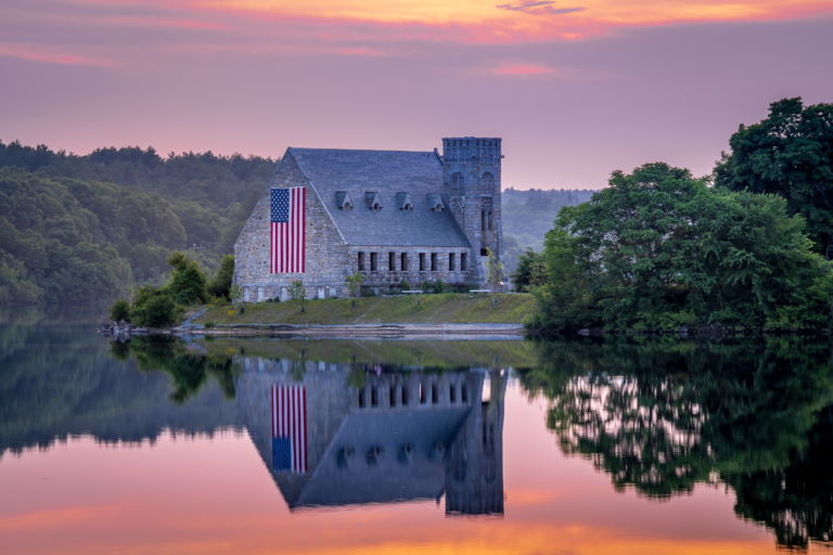 Old Stone Church reflected in the Wachusett Reservoir at sunset.